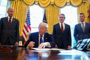 U.S. President Donald Trump signs an executive order in the Oval Office at the White House in Washington, D.C.