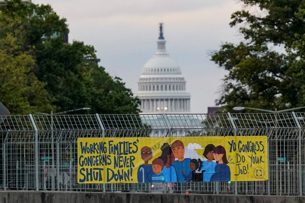 A view of a working families poster as the U.S. Capitol is seen in the background, as the deadline to avert a partial government shutdown approaches at the end of the day on Capitol Hill