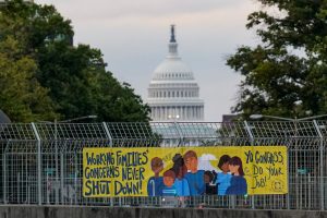 A view of a working families poster as the U.S. Capitol is seen in the background, as the deadline to avert a partial government shutdown approaches at the end of the day on Capitol Hill