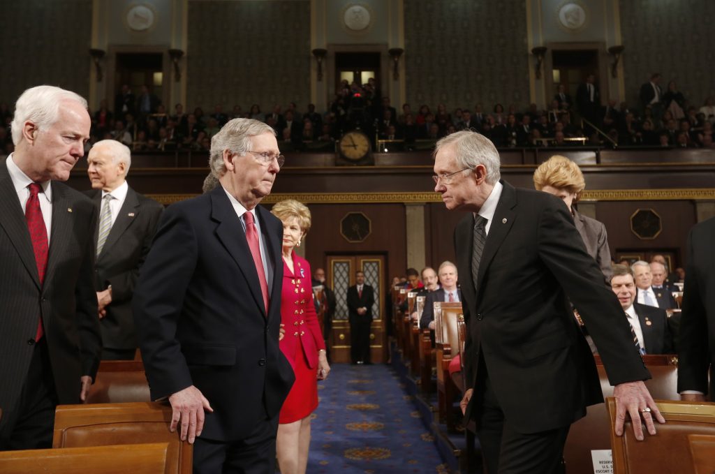 U.S. Senate Minority Whip Cornyn, Senate Minority Leader McConnell and Senate Majority Leader Reid head to the front of the chamber together before President Obama delivers his State of the Union speech in Washington